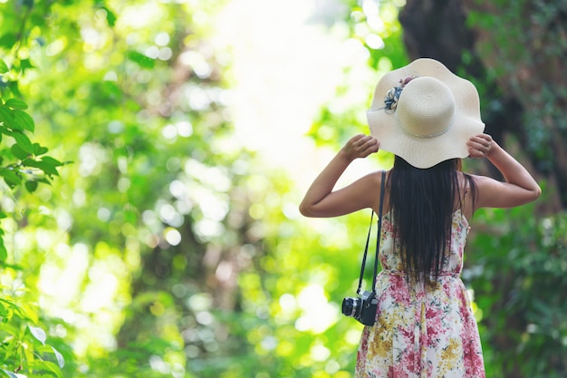 La parte posteriore della ragazza felicità indossando un cappello di paglia in giardino