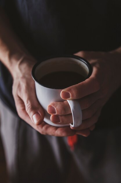 La persona che tiene il caffè nero