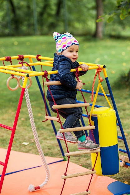 La piccola bambina che gioca al parco giochi all'aperto