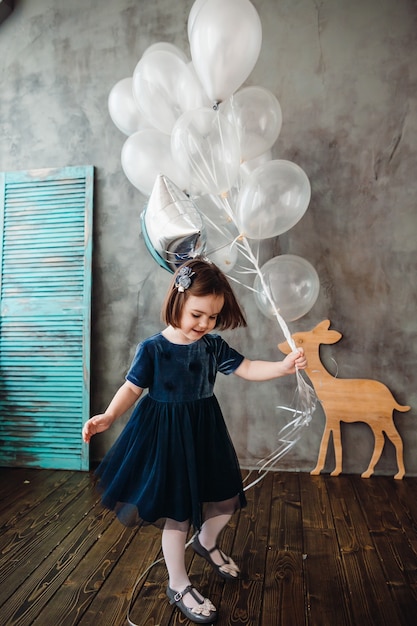 La piccola ragazza continua a ballons nella stanza