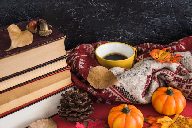 La pila di libri si avvicina ai simboli di autunno e della bevanda