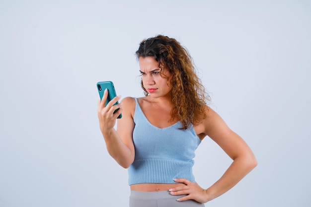 La ragazza arrabbiata sta parlando in videochiamata su sfondo bianco