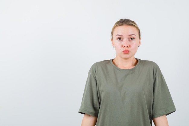 La ragazza bionda sta guardando sorprendendo su sfondo bianco