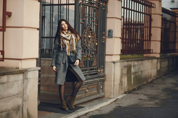 La ragazza cammina. Donna in un cappotto. Bruna con una sciarpa.