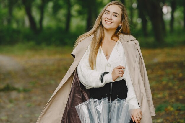 La ragazza cammina. Donna in un cappotto marrone. Bionda con l'ombrello.