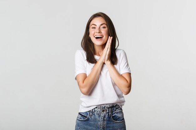 La ragazza castana sorridente allegra strofina le mani e aspetta il gusto.