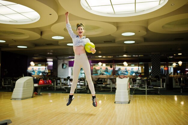 La ragazza con la palla da bowling sul vicolo ha giocato al club di bowling