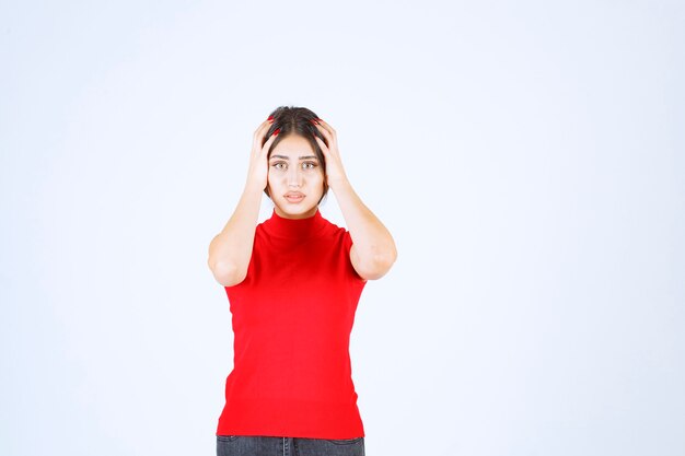 La ragazza con una camicia rossa sembra spaventata e terrorizzata.