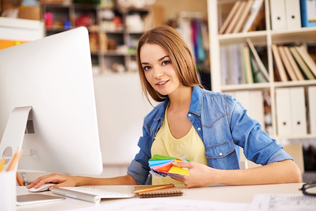 La ragazza con una tavolozza di colori e un computer