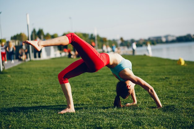 La ragazza è impegnata in ginnastica mattutina nel parco.