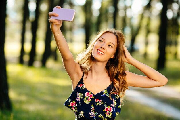 La ragazza felice fa selfie su uno smartphone