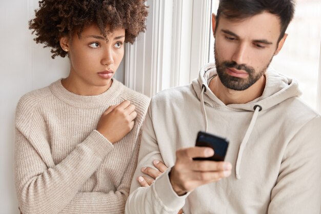 La ragazza gelosa si sente triste mentre scrive con qualcuno