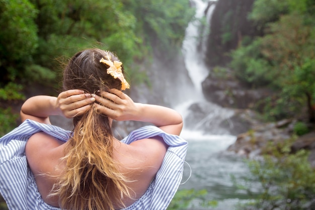 la ragazza guarda indietro la cascata