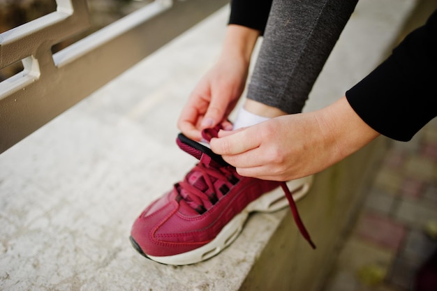 La ragazza ha i lacci in maglia di allenamento sulle sneakers Sport fitness street workout concept
