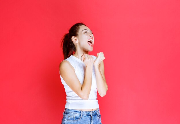 La ragazza in camicia bianca sembra positiva e invitante.