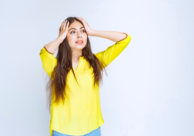 La ragazza in camicia gialla sembra confusa e dubbiosa.