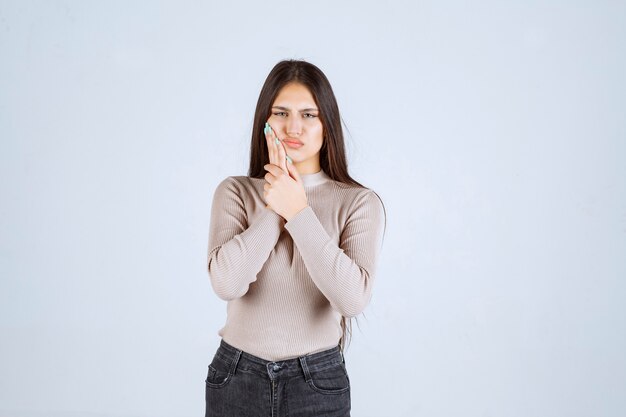 La ragazza in camicia grigia sembra assonnata.