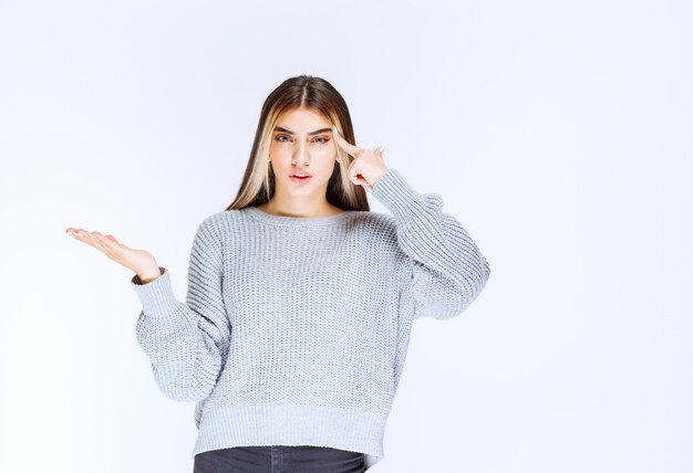 La ragazza in camicia grigia sembra confusa e pensante.