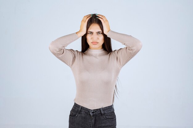 La ragazza in camicia grigia sembra sorpresa e confusa.