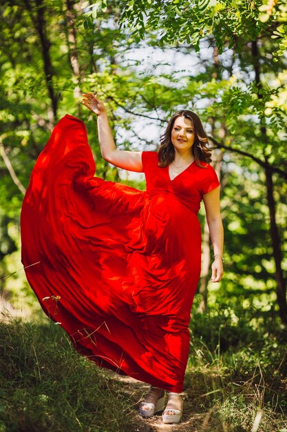 La ragazza incinta camminando lungo la foresta