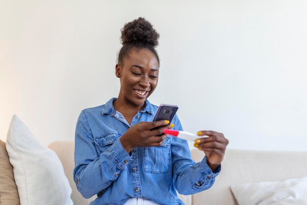 La ragazza incinta felice sta mostrando il suo test di gravidanza e sta facendo videochiamate per fare selfie Donna felice che scatta foto del test di gravidanza con il telefono cellulare e pubblica foto sui social media