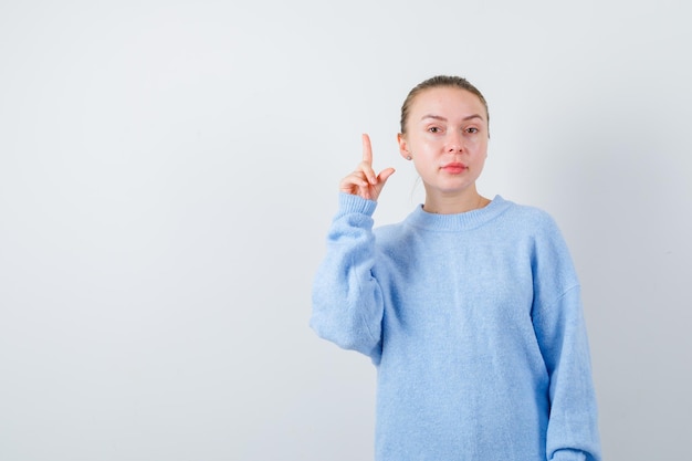 La ragazza piacevole sta mostrando le sue dita su sfondo bianco