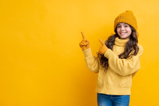 La ragazza si è vestita densamente su una priorità bassa gialla