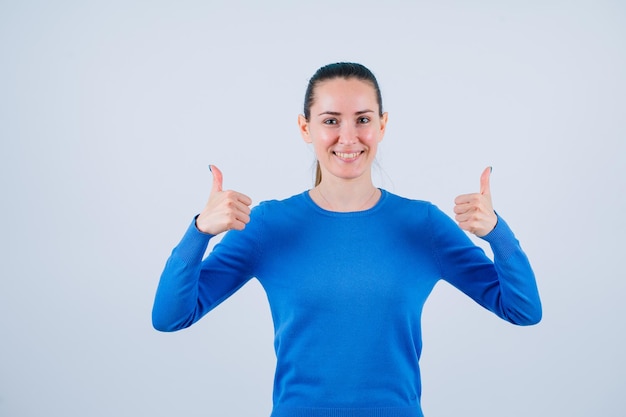 La ragazza sorridente sta mostrando i gesti perfetti su fondo bianco