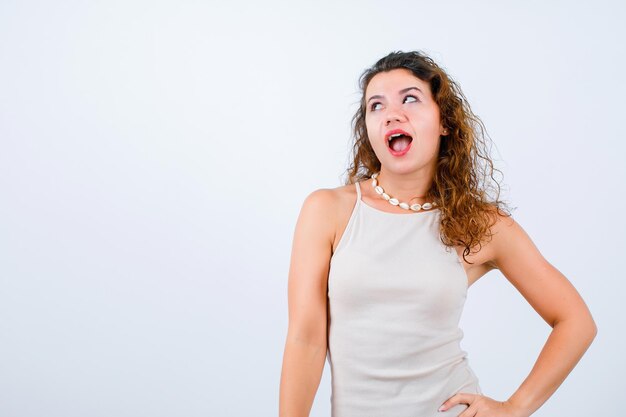 La ragazza sta alzando lo sguardo e sta mettendo la mano sulla vita su fondo bianco