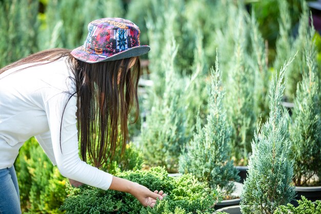 La ragazza sta ammirando i fiori nel giardino.