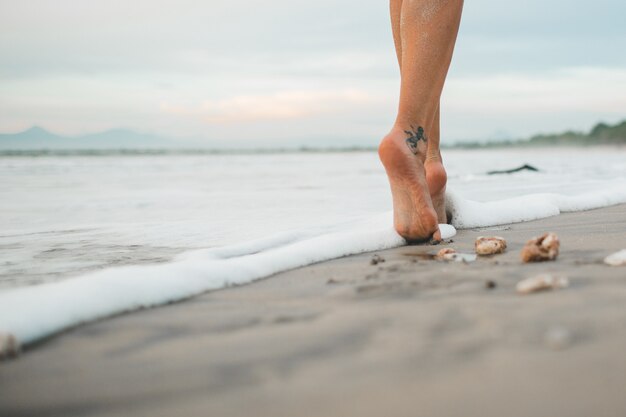 la ragazza sta camminando lungo la spiaggia