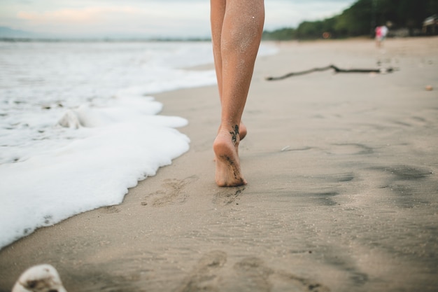 la ragazza sta camminando lungo la spiaggia