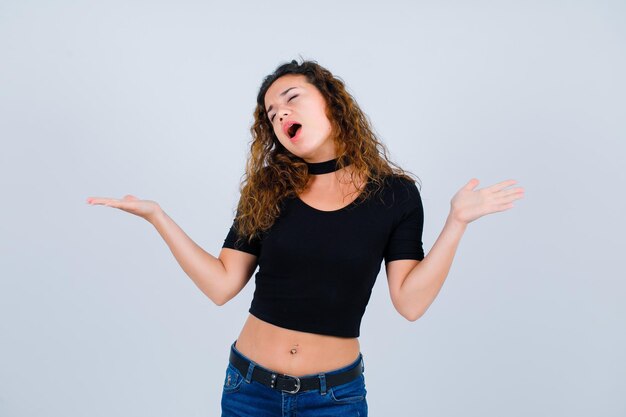 La ragazza sta cantando spalancando le mani su sfondo bianco