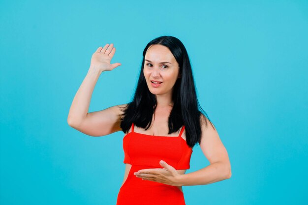 La ragazza sta mostrando i gesti delle mani su sfondo blu