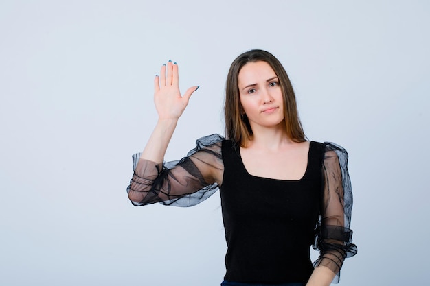 La ragazza sta mostrando il gesto di arresto alzando la mano su sfondo bianco