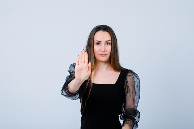 La ragazza sta mostrando il gesto di arresto con la mano su priorità bassa bianca