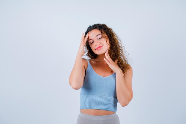 La ragazza sta tenendo le mani sulla fronte e sul mento su priorità bassa bianca