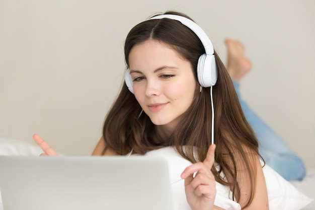 La ragazza teenager ascolta la scelta e l&#39;acquisto delle canzoni online