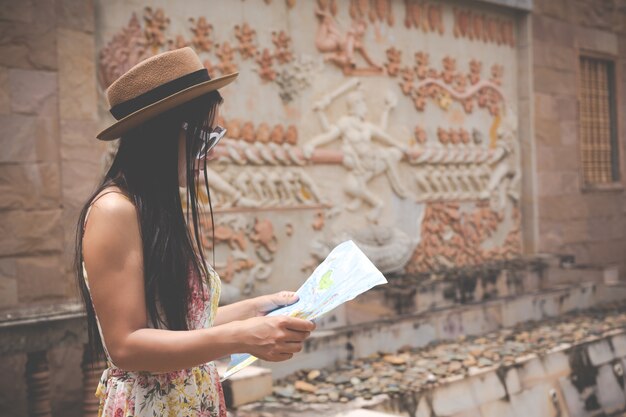 La ragazza tiene una mappa turistica nella città vecchia.