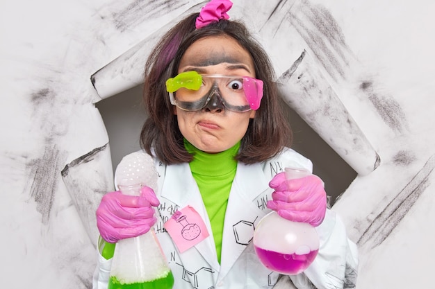 la ricercatrice svolge ricerche nel laboratorio di chimica tiene oggetti di vetro con liquido colorato studia il livello di atomi e molecole analizza i composti per determinare le proprietà fisiche