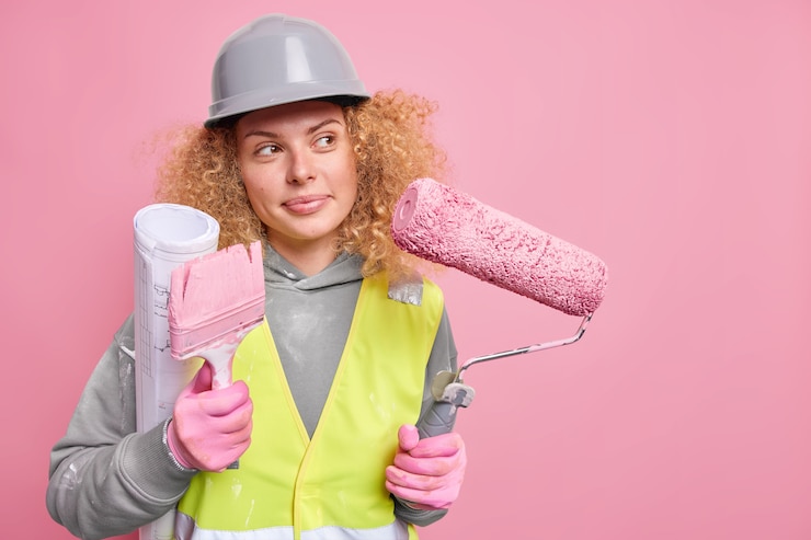 Foto gratuito la riparatrice donna pensa al design della casa porta il rullo e la spazzola del progetto vestito con abiti da lavoro