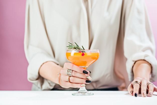 La rosa cocktail esotici e frutta e mano femminile