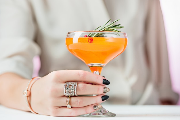 La rosa cocktail esotici e frutta e mano femminile