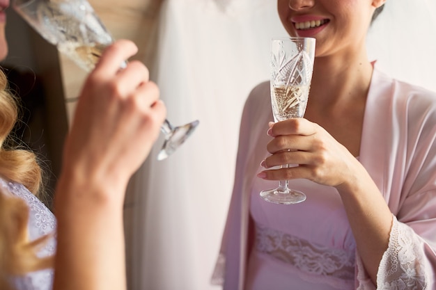 La sposa e le damigelle d&#39;onore bevono champagne preparando al mattino