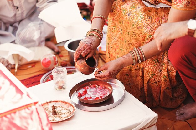 La sposa indiana lava i dadi sul piatto con specie e petali