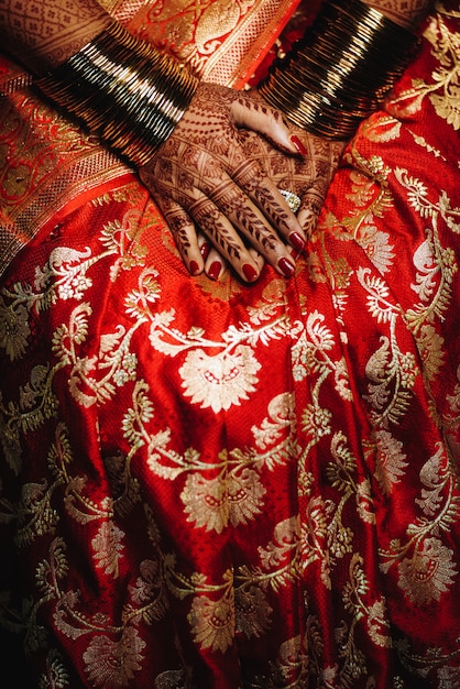 La sposa indù mostra le sue fedi nuziali sulle mani con il tatt dell&#39;henné