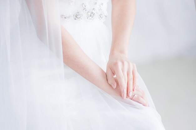 La sposa tiene le mani incrociate sulle ginocchia