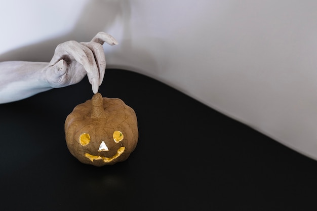 La stordina tocca la mano a jack-o-lanterna