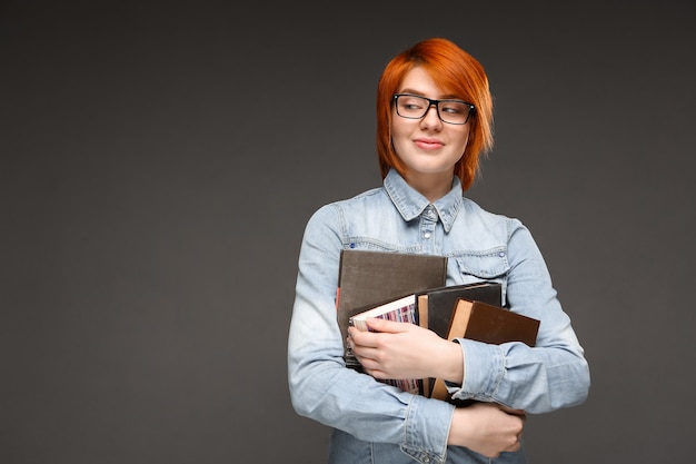 La studentessa nerd rossa porta i libri