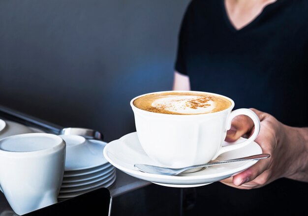 La tazza di caffè viene servita dal barista nel negozio di camere oscure